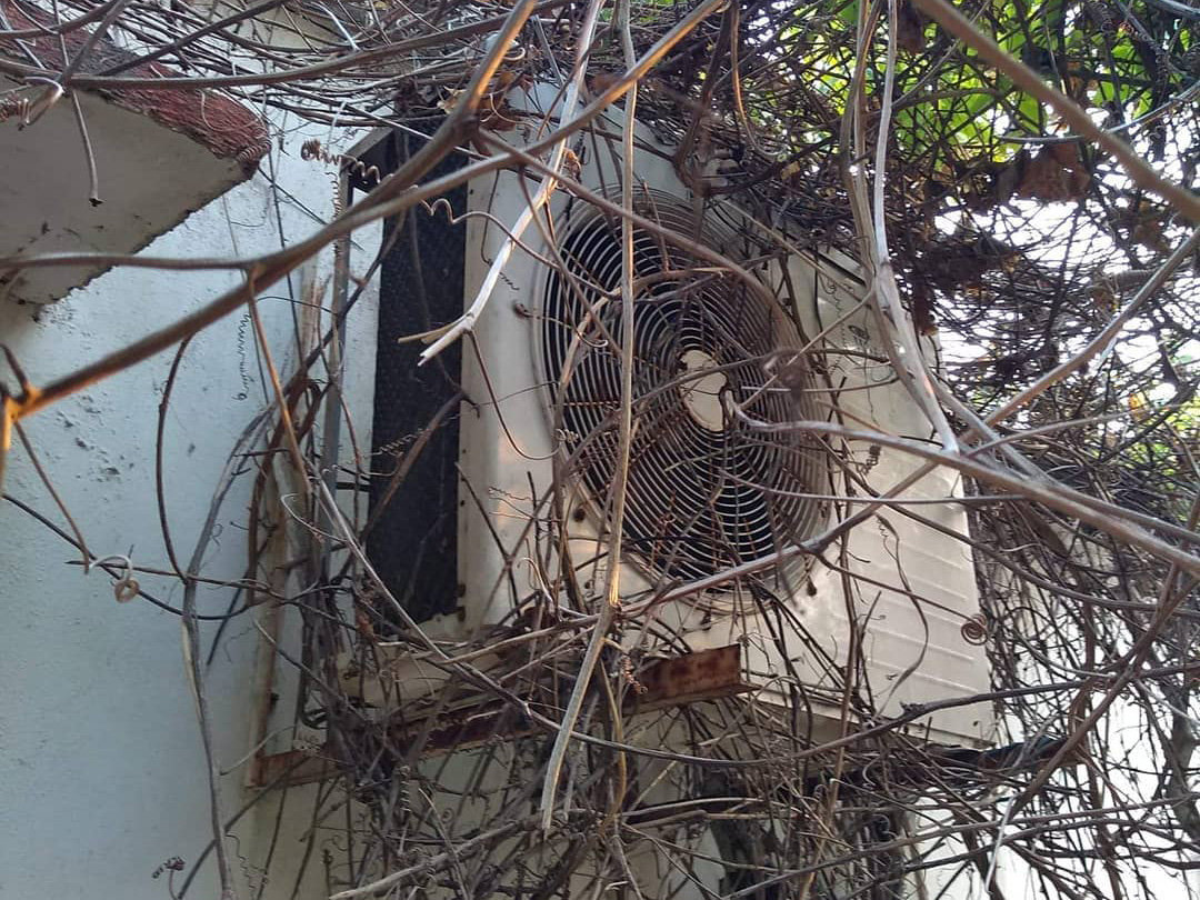 An outdoor air conditioning unit badly restricted