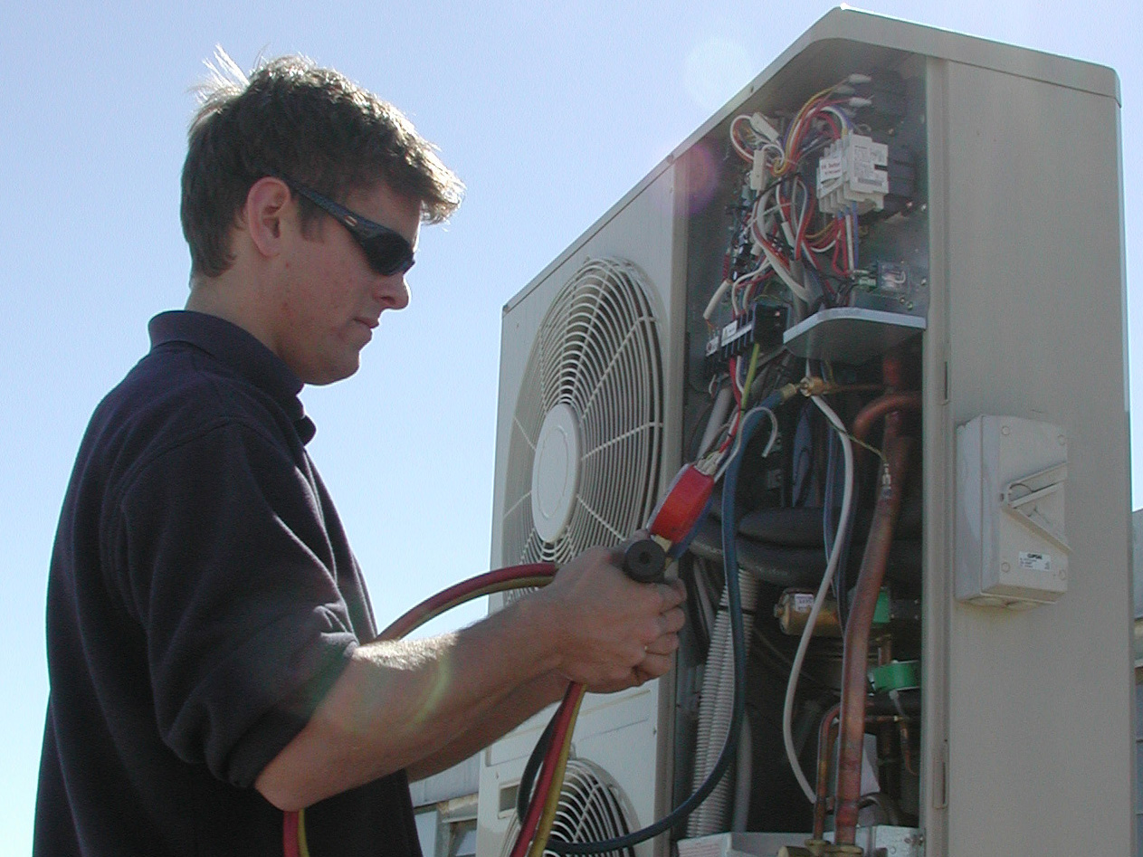 Mechanic working on a Mitsubishi Electric outdoor unit